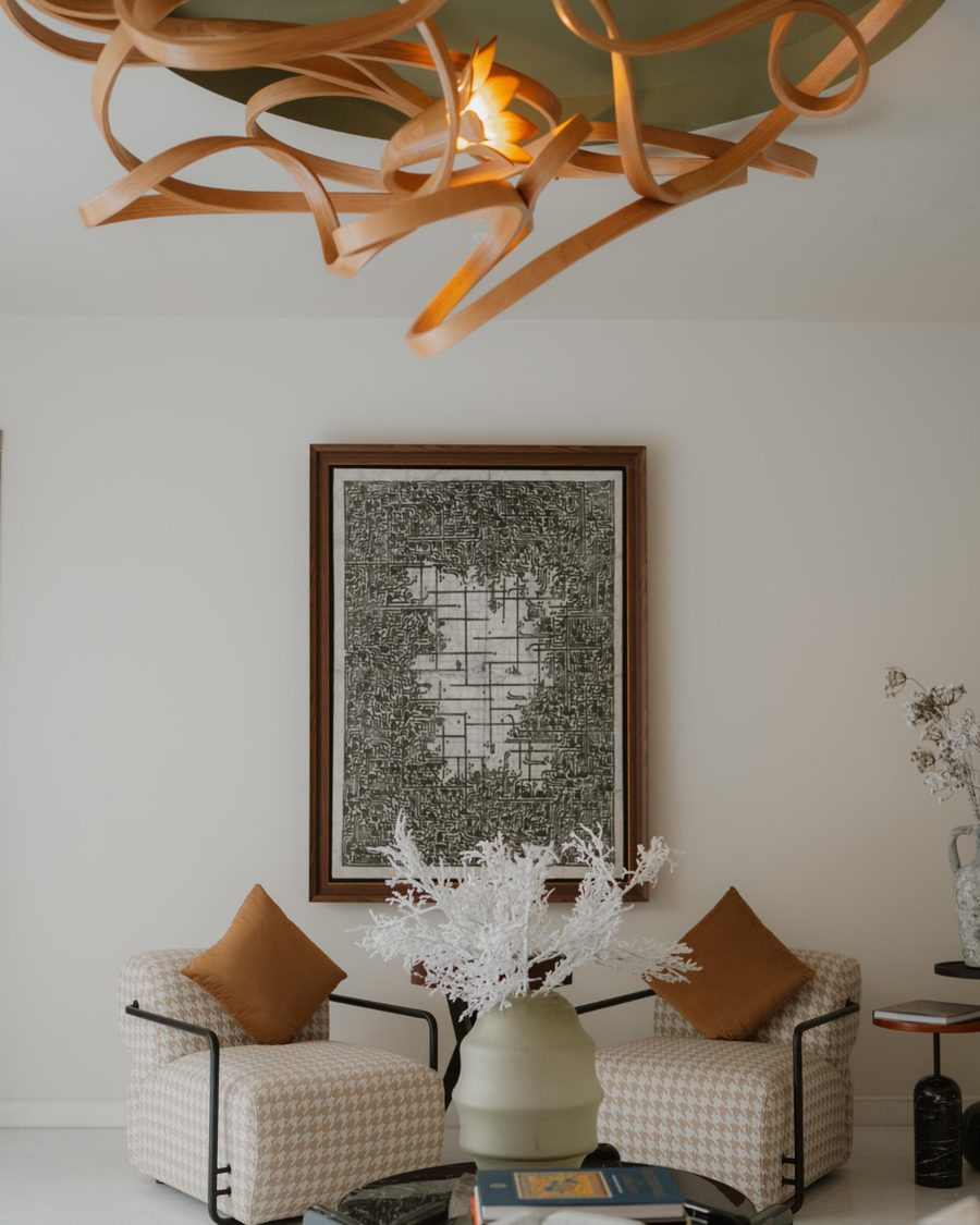 A carved timber ribbon light above a lounge