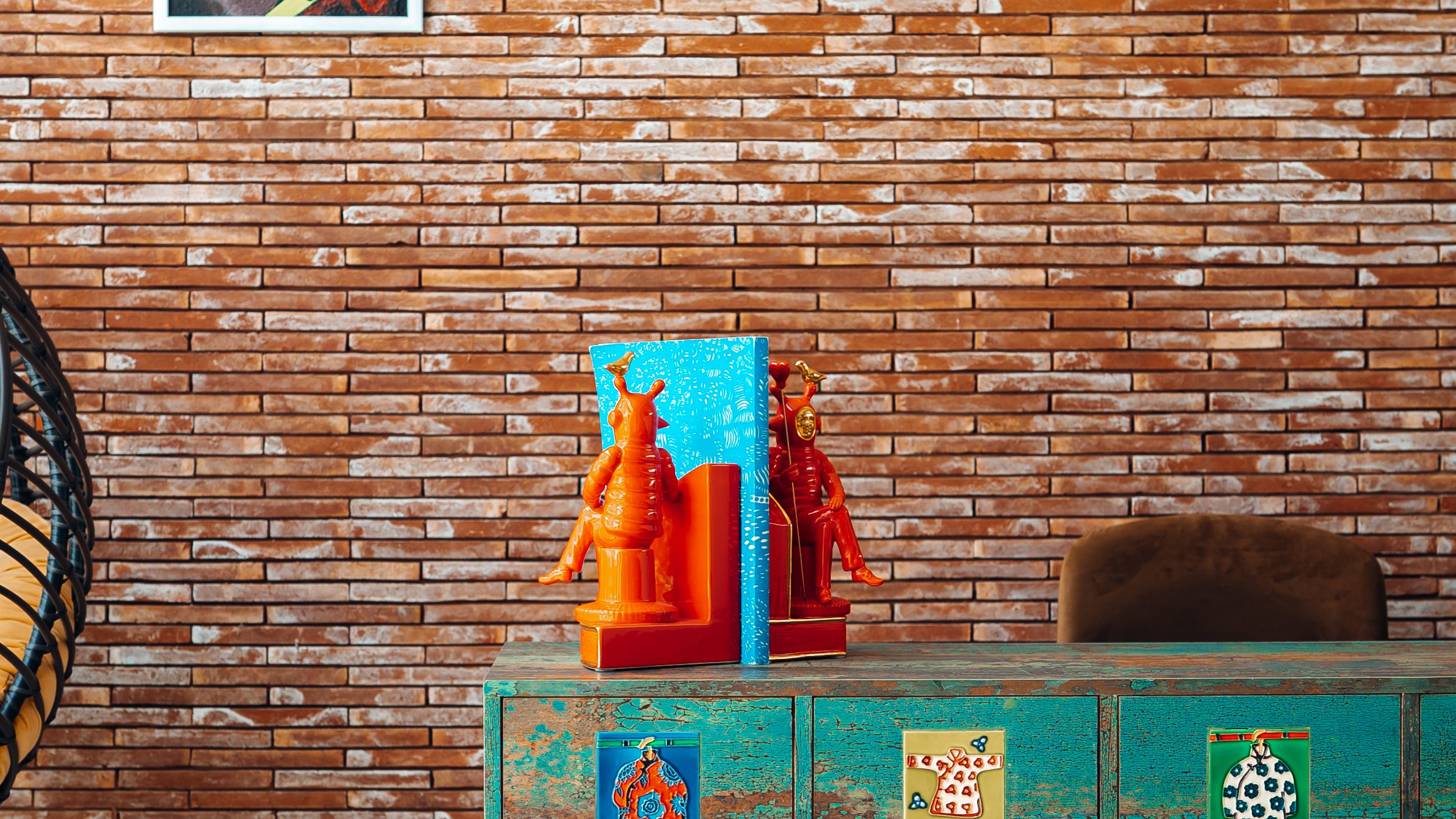 Brick-walled study with a turquoise painted desk and vinyl records